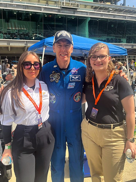 Three people standing in pit row at Indianapolis Motor Speedway