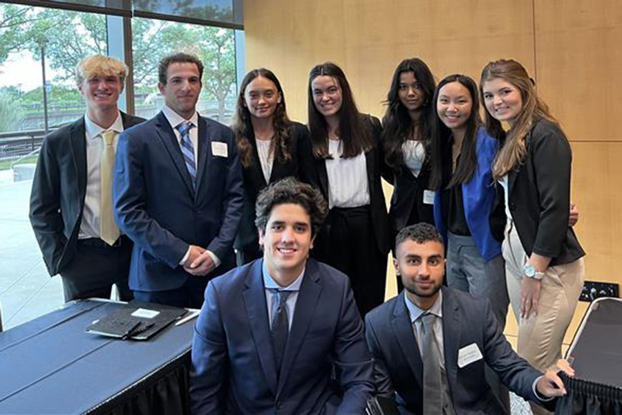 Group of students in suits and suit jackets smiling