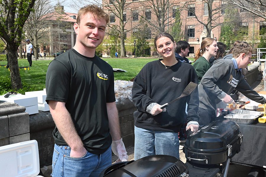 Two students working grills outside on Purdue's campus