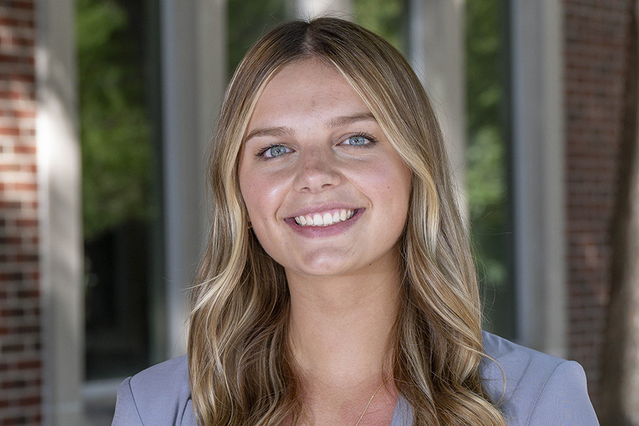 Student with blonde hair and blue eyes, smiling