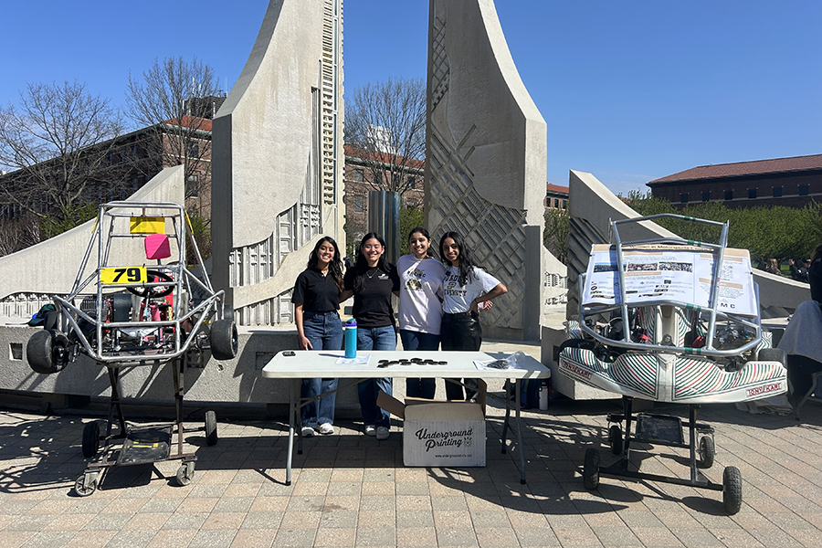 Students standing near the engineering fountain surrounded by gokarts
