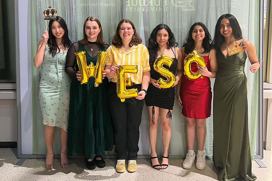 Group of students holding gold balloons that spell "WESO"
