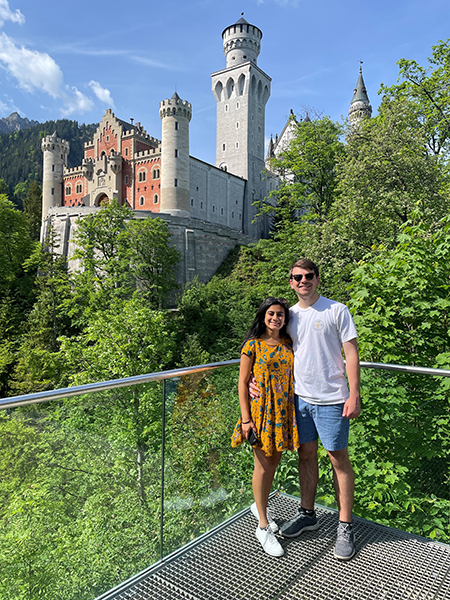 Two people standing in front of a castle