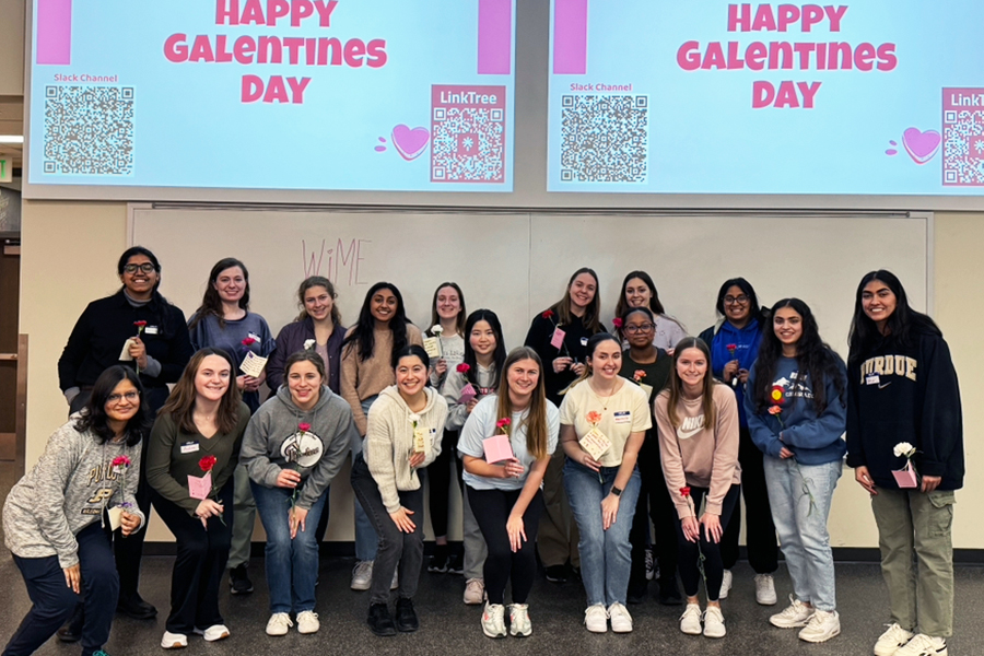 Pandya and group of students holding holds at Galentines event