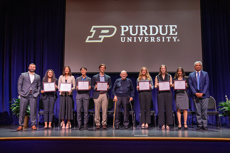 Students standing on stage with their certificates