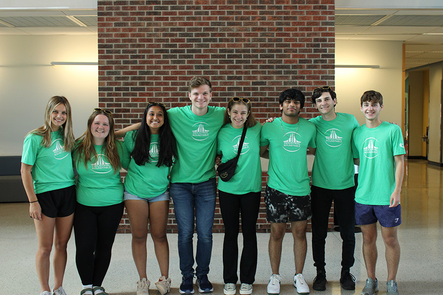 Students wearing green sheets with Industrial Roundtable design