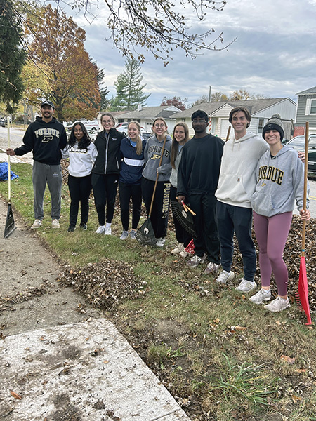 Group of students outside with rakes