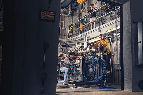 Three individuals working on a machine