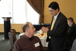 Robert Frosch (L) speaks with Dean Mung Chiang (standing)