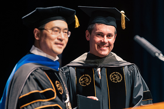 Mung Chiang, president of Purdue Univesity, and Dave Ricks in cap and gown.