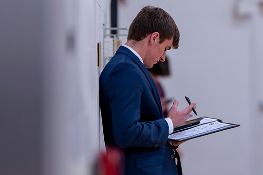 Student looking at papers in folder.