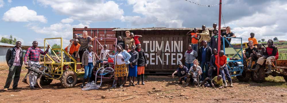 group of people standing in front of a Tumaini Center building