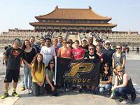 Students in from of a temple in China holding a Purdue Flag
