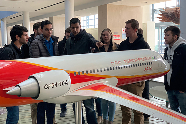 Students in front of a replica plane