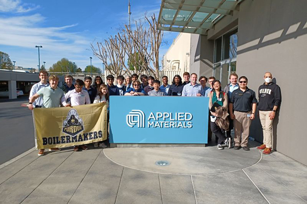 Group of students outside with Boilermaker flag and an Applied Materials sign