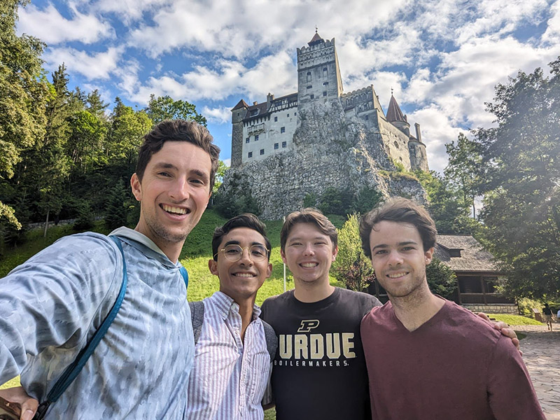 A group of students standing in front of a castle.