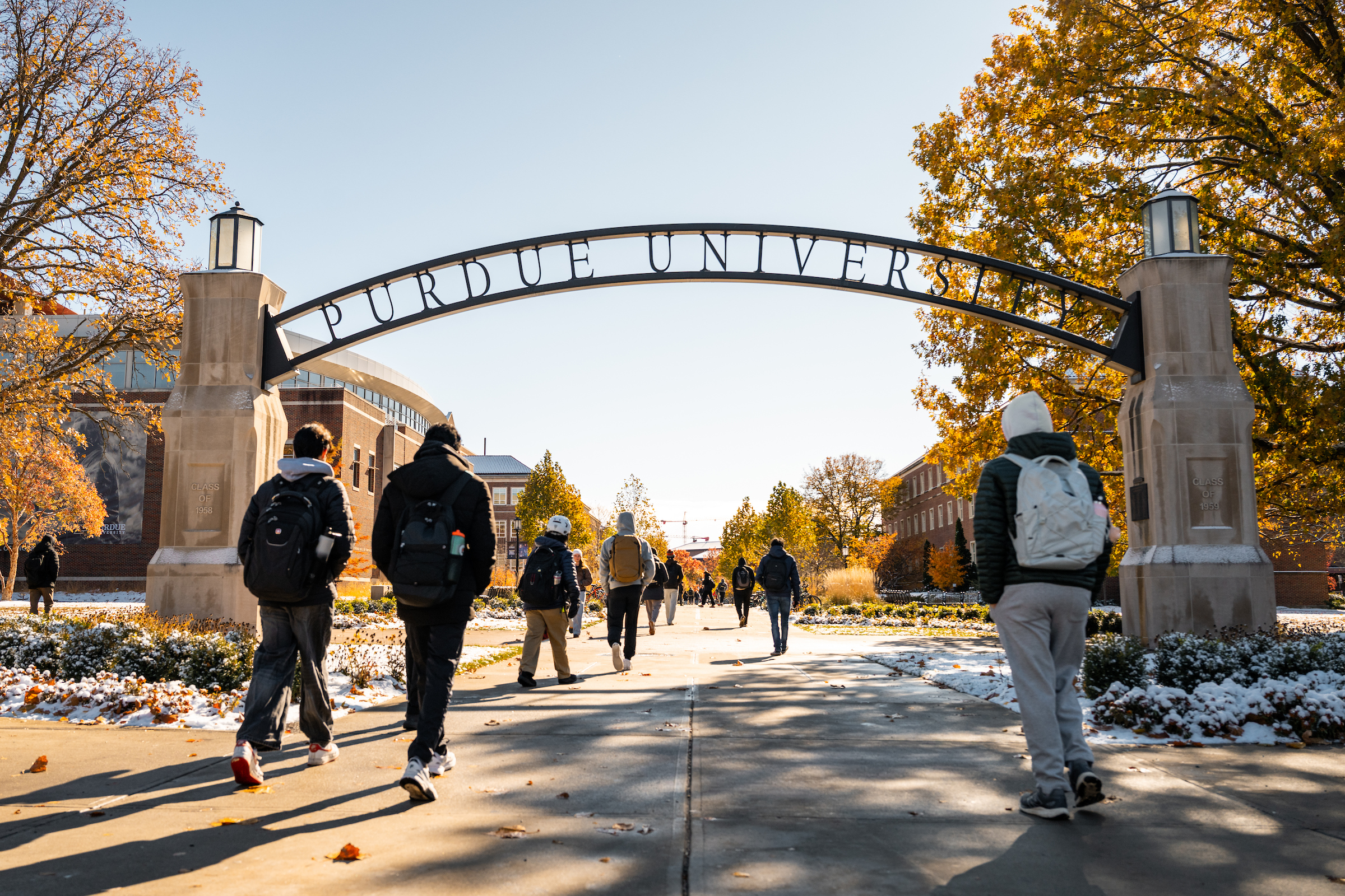 Students walking under the Purdue University arch