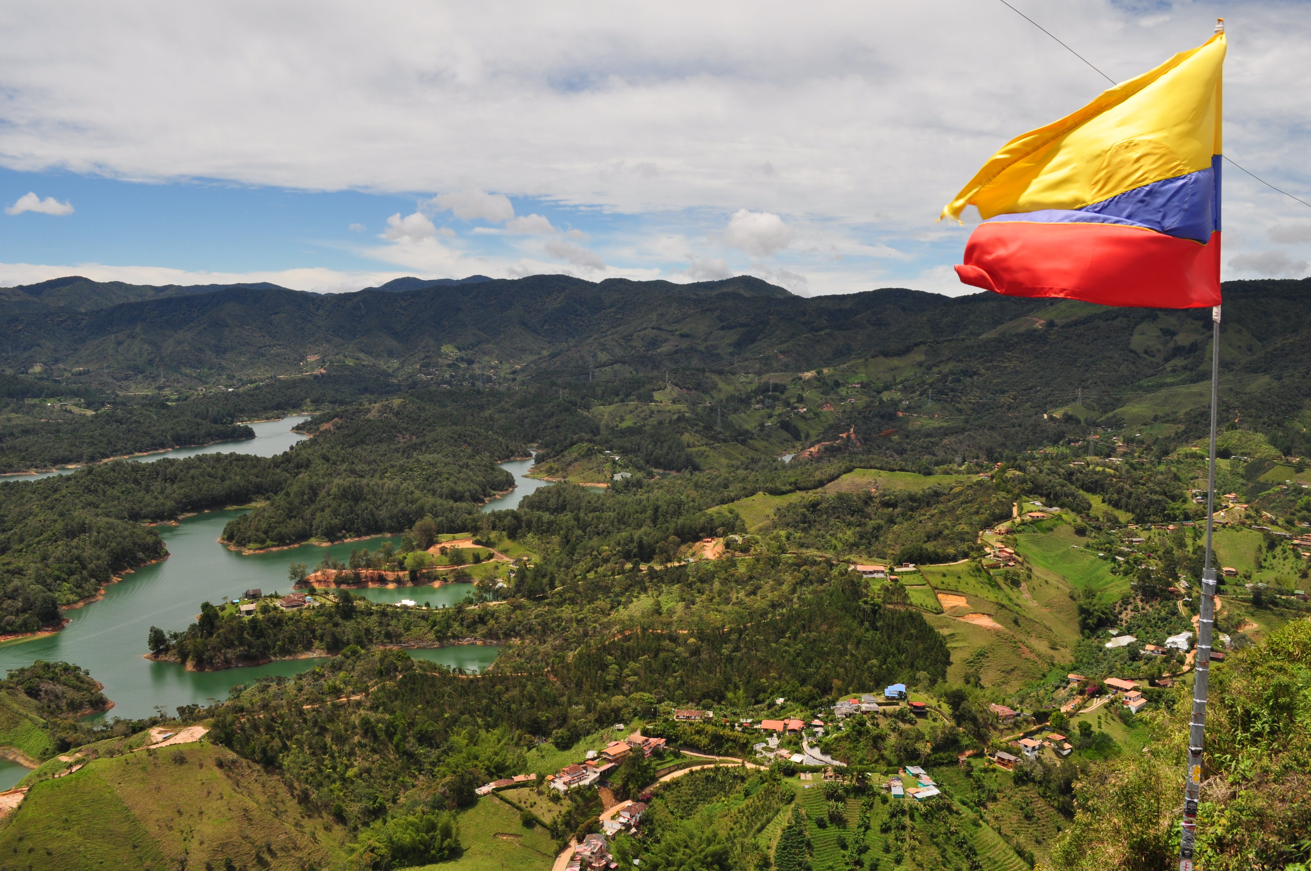 Colombia flag above a hilly landscape