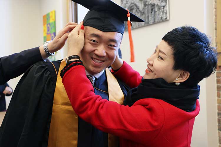 Yingnan Guo's mother helps adjust his cap