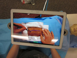 A monitor overlaying surgery on a test dummy