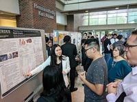 Photo of Xiang Feng presenting poster