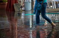 Woman carrying child through flooded street