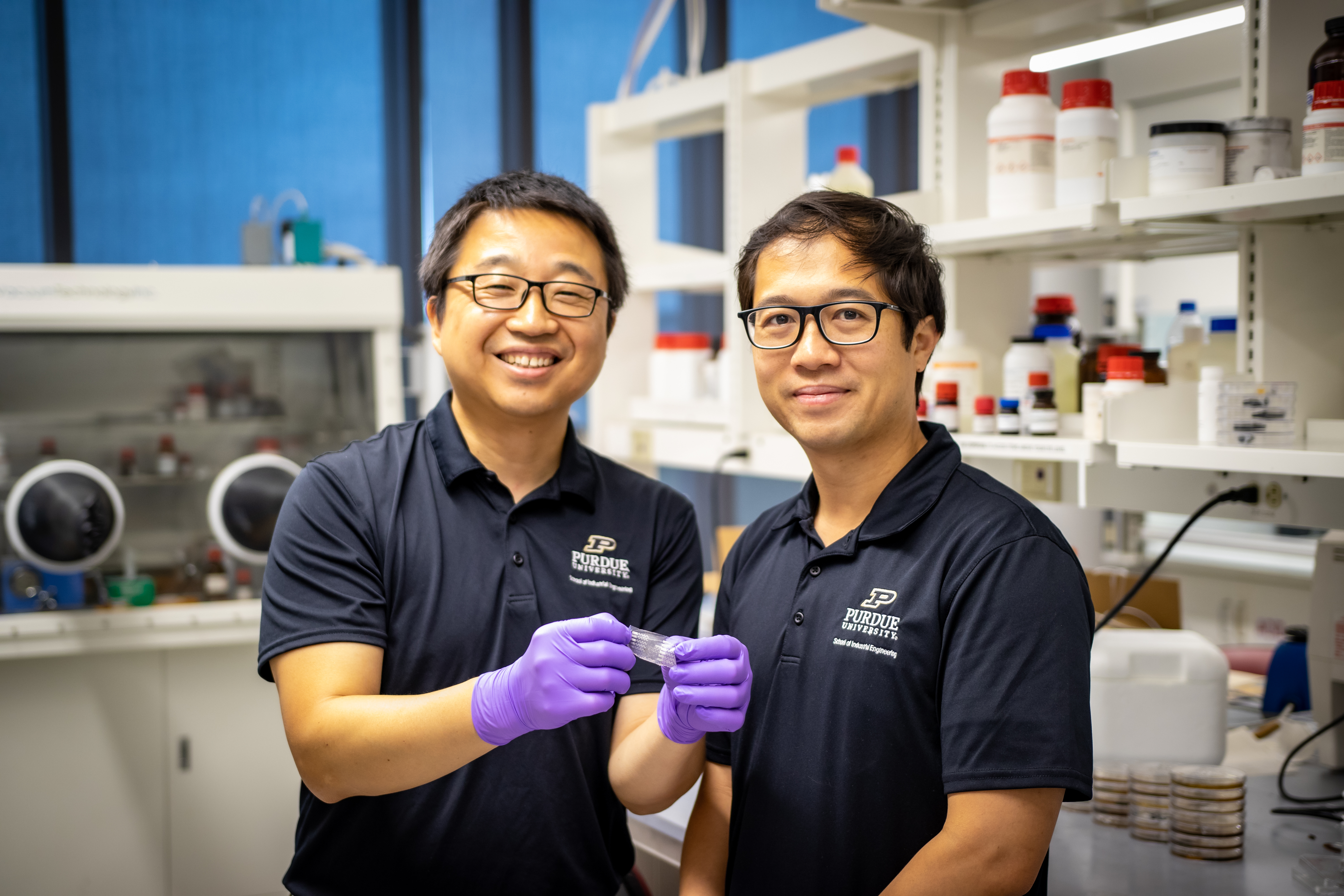 Professors Wenzhuo Wu (left) and Denny Yu pose with their wearable sensor