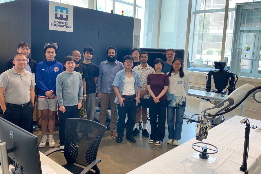 Yu She and MARS Lab Team posing for a photo with robotics equipment in build at scale lab. 