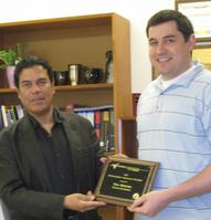 Ahmed Hassanein, Head of the School of Nuclear Engineering presenting Dan Rokusek with Outstanding Graduate Student Plaque
