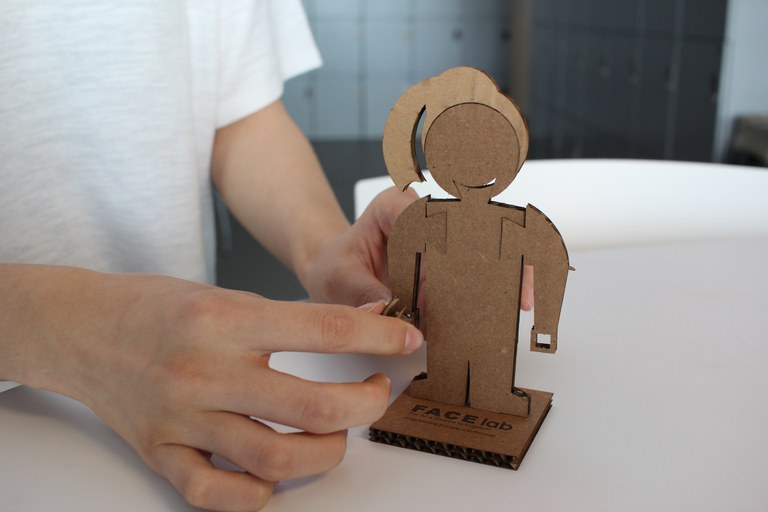 Child makes engineer figure from cardboard