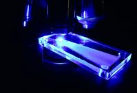Acrylic microchannel fluorescing blue under microscope objectives