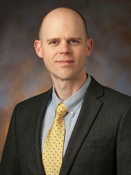Portrait of a man in a gray suit and yellow tie