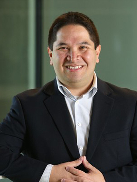 Man in black suit on green hallway background