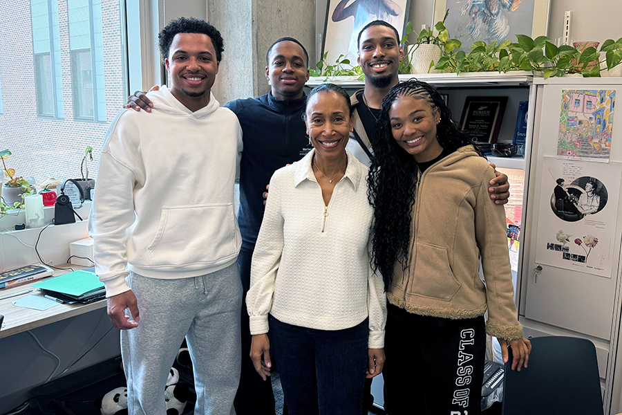 Four students and Tamara Markey, smiling, standing in her office