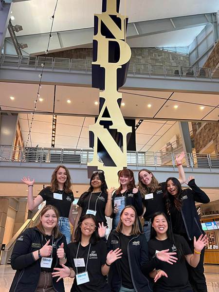 group of women posing in front of sculpture that says "Indiana"