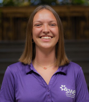 Student with long brown hair, smiling, wearing purple SWE polo, head shot