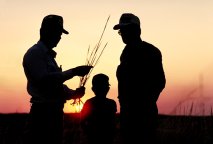 Two farmers and child at sunset