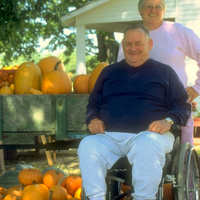 Paraplegic farmer and his wife enjoying their harvest of pumpkins together