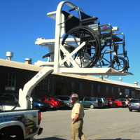 Wheelchair being lifted onto the bed of a pickup truck with a custom lift