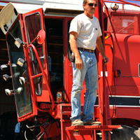 Farmer uses a custom lift to get down from the cab of a combine