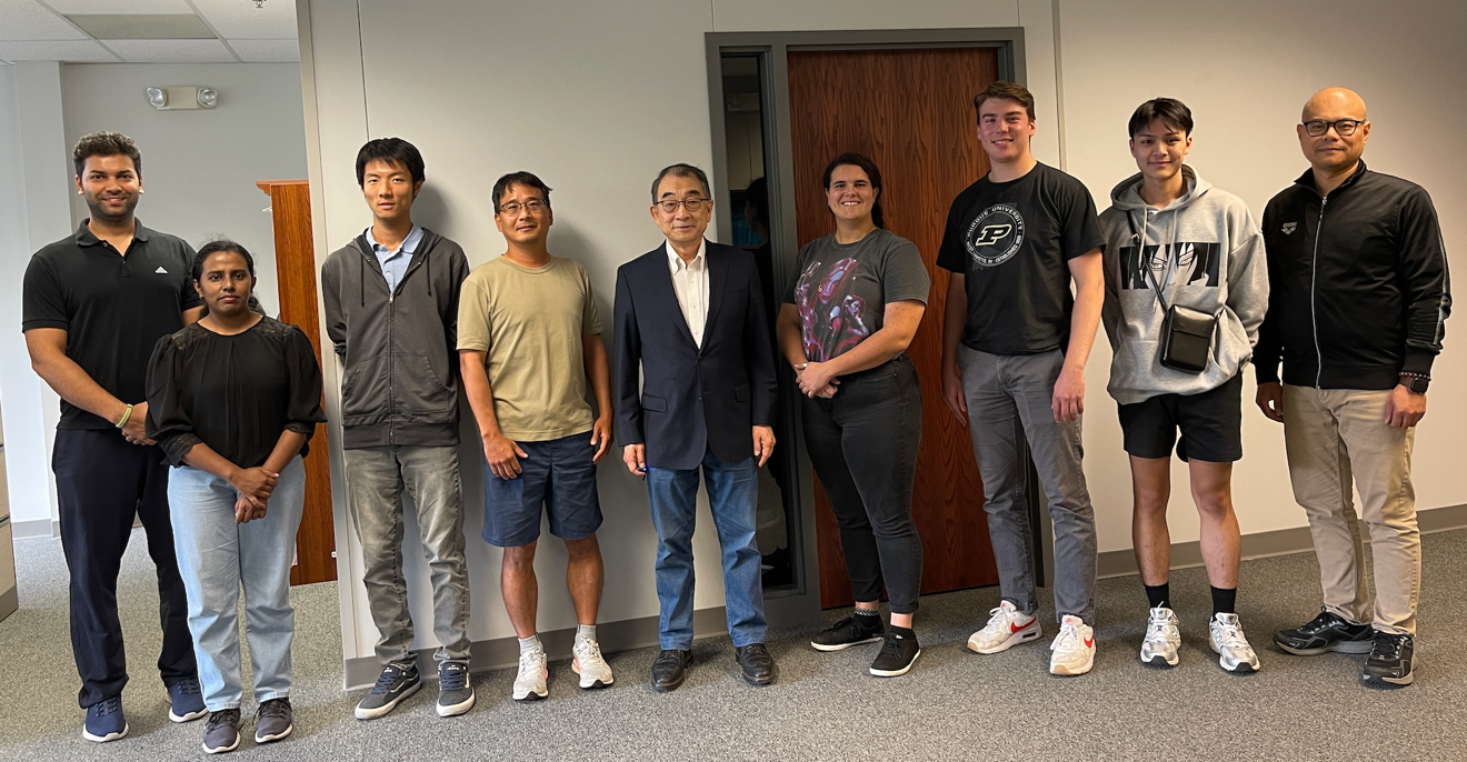 A group of people standing in a room
Description automatically generated